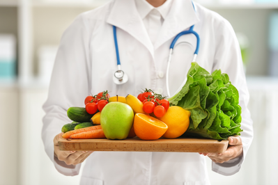 doctor holding tray of fruit and vegatbles